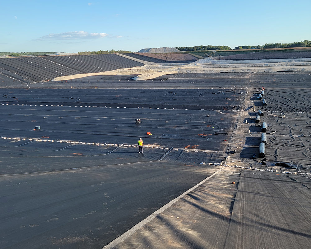 Ongoing Geosynthetic Layers Installation with Staged Materials Ready to be Deployed